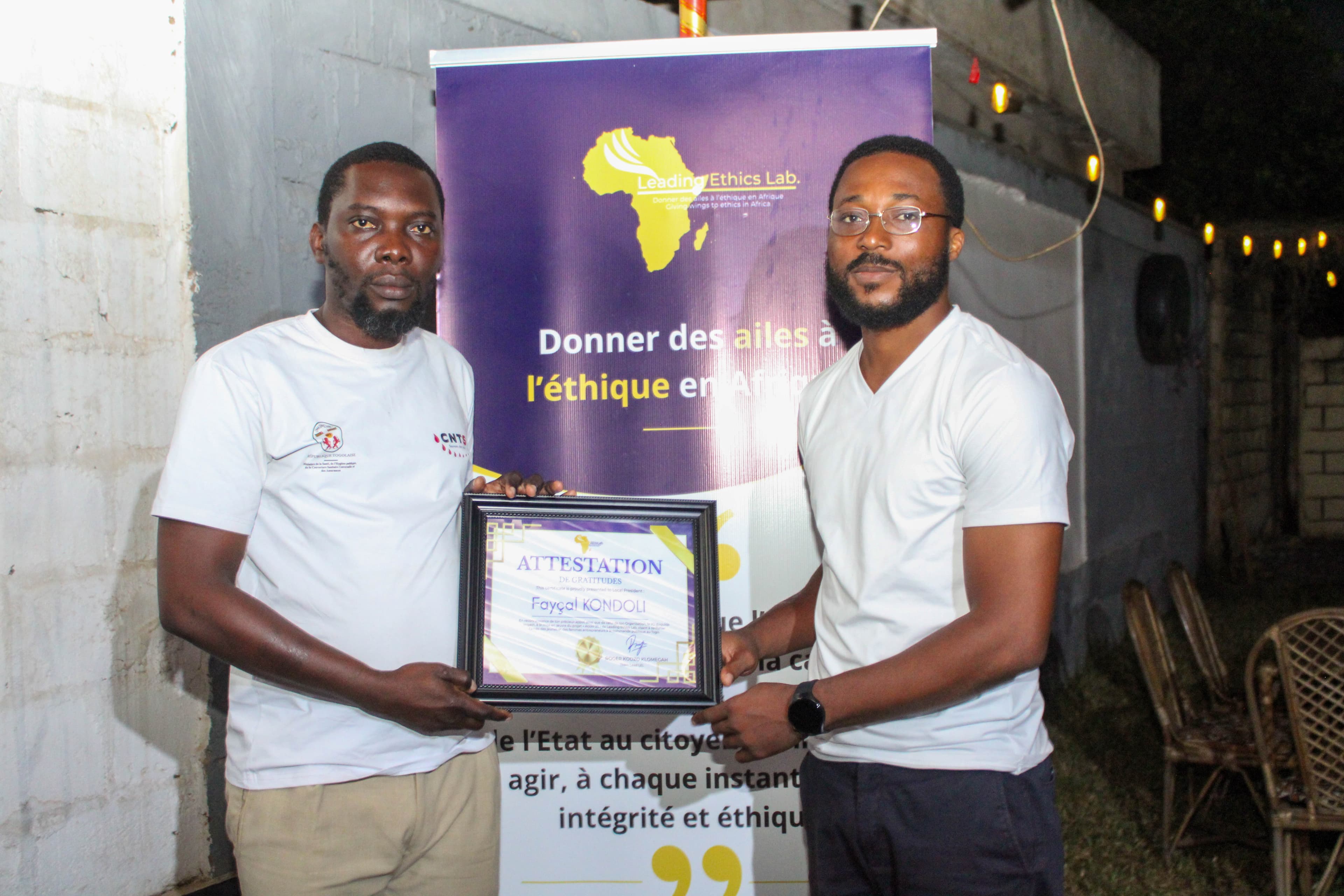 Biova MENSAH remettant le tableau de remerciement au partenaire de la JCI Baguida Impact